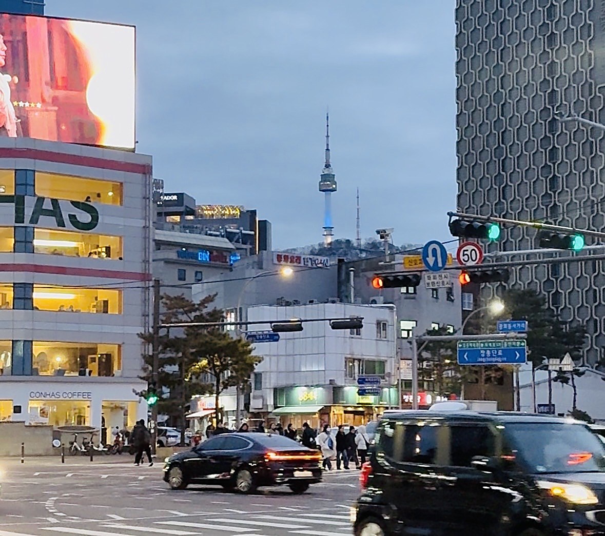 夕方のソウルの交差点とNソウルタワー。行き交う人と車