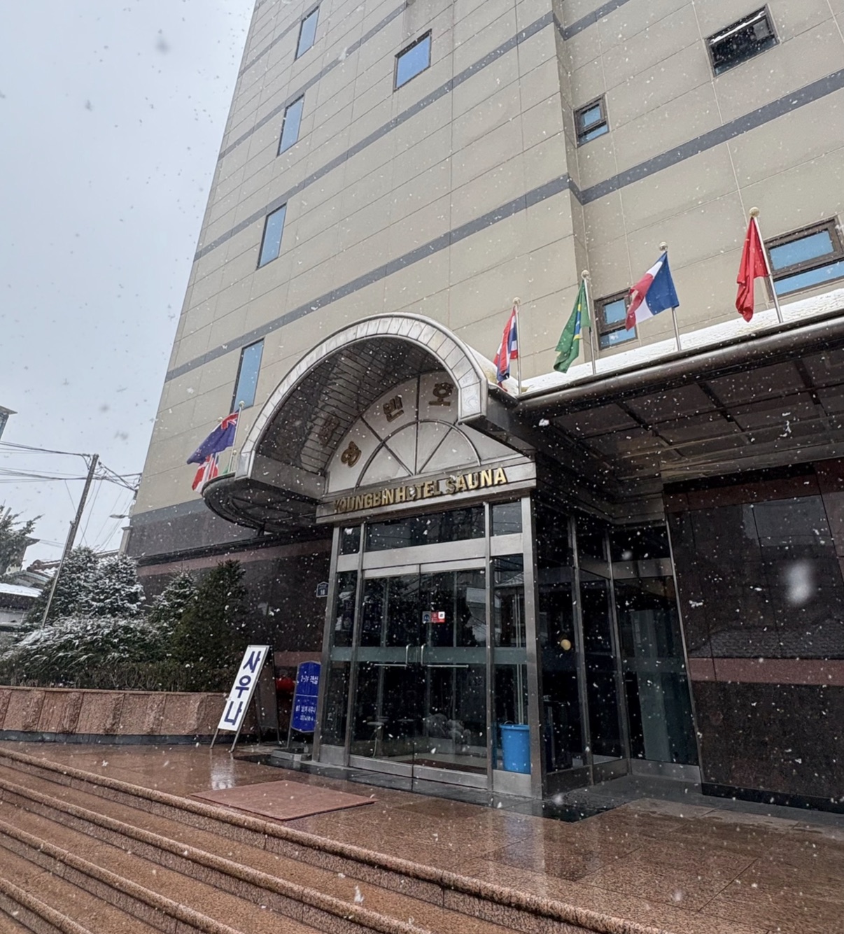 ヨンビンホテル(東大門)の外観。入口の上に YOUNGBIN HOTEL SAUNA の看板が出ている(雪の日)