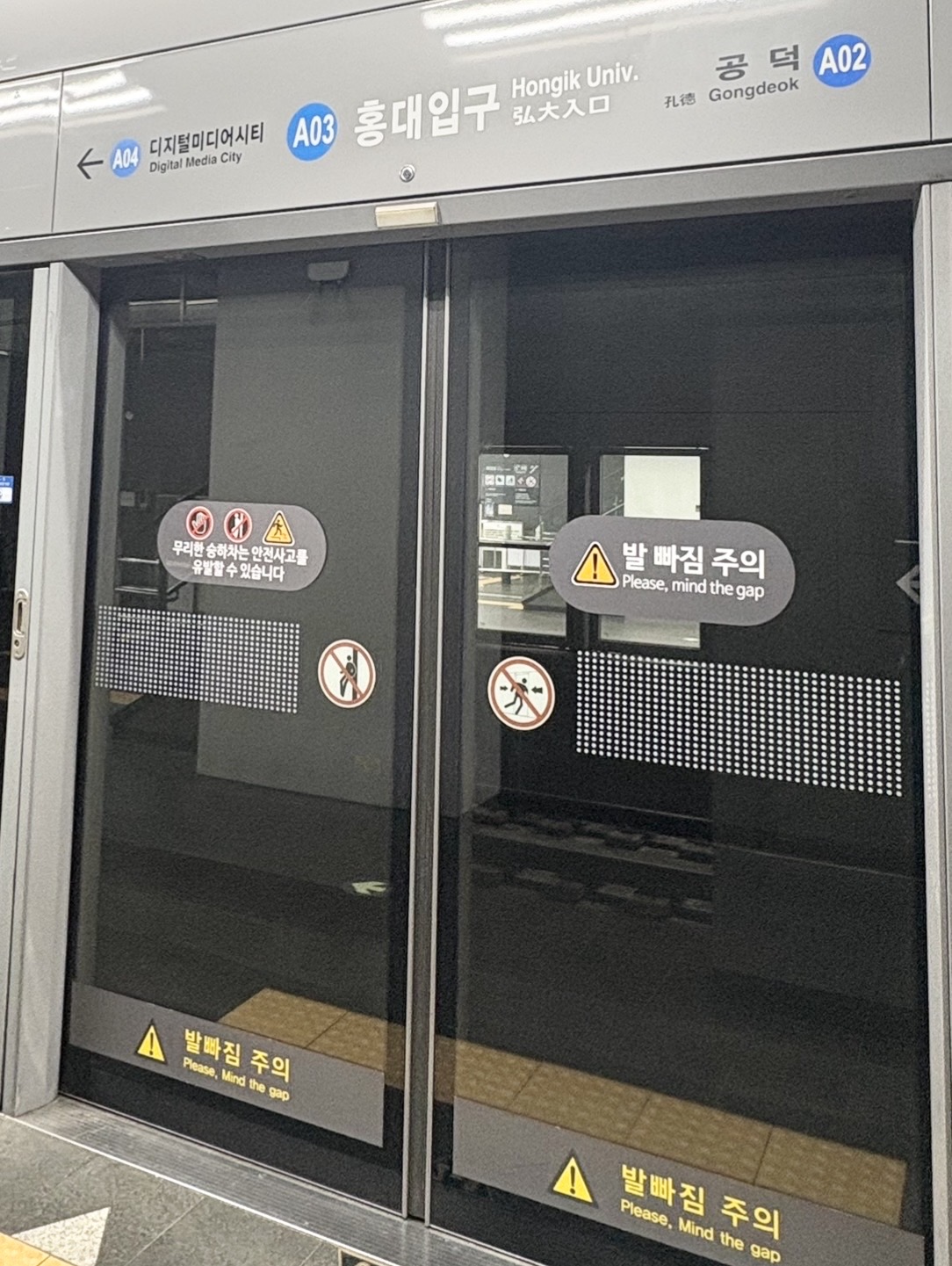 ソウルの地下鉄ホーム。弘大入口駅のホームドアと駅名表示